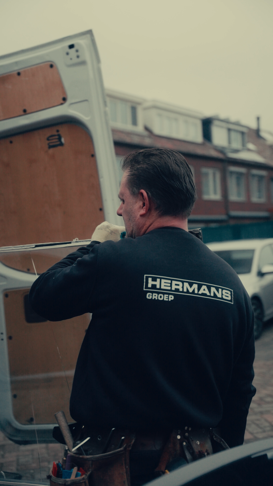 Glaszetter van Hermans Groep tilt een glasruit uit de bedrijfsbus